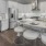 Bright white kitchen with island, granite countertops and pendant lighting.