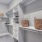 Walk-in closet with wood shelves and drawers.